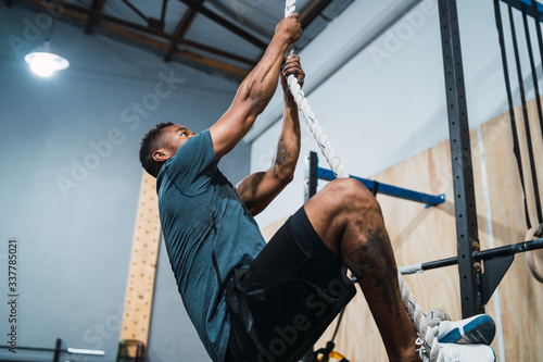 Athletic man doing climbing exercise.