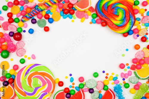 Colorful mixed candies. Top view frame over a white background.