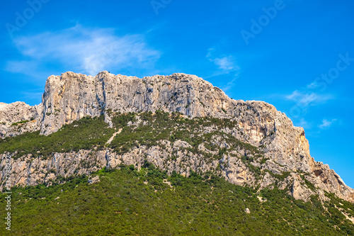 Panoramic view of cliffs and slopes of main limestone massif, Monte Cannone peak, of Isola Tavolara island on Tyrrhenian Sea off northern coast of Sardinia, Italy