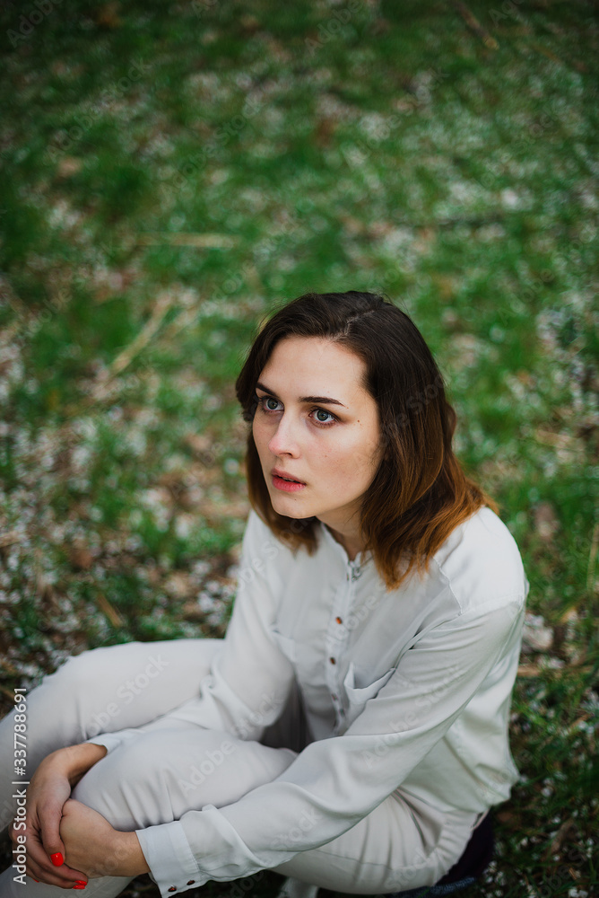 Beautiful young girl is resting and enjoying spring in the spring park Beautiful young girl is resting and enjoying spring in the spring park