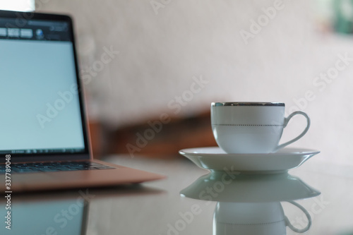 Coffee cup next to a laptop for home office