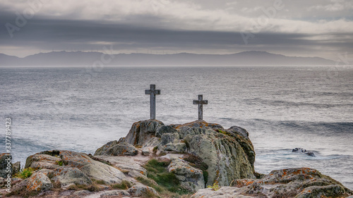 Two crosses on a rock at Cape Roncudo in La Coruña, Galicia, Spain.
