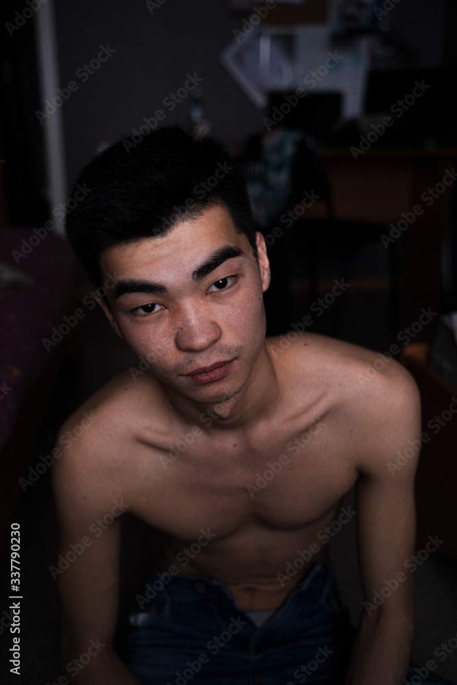 portrait of an asian guy without a t-shirt at home, in the studio, look at the camera portrait of an asian guy without a t-shirt at home, in the studio, look at the camera