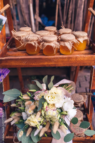 Glass jars of honey covered with burlap