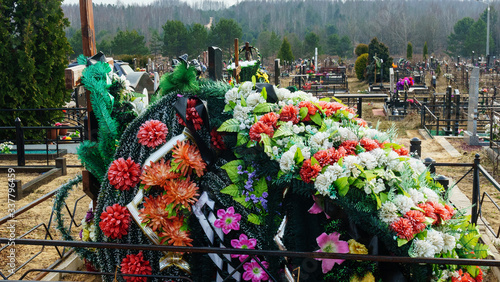 A wreath of arificial flowers on a new burial. Coronavirus concept. photo