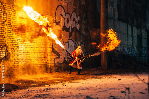 Santa Claus with flamethrowers in an abandoned warehouse photo