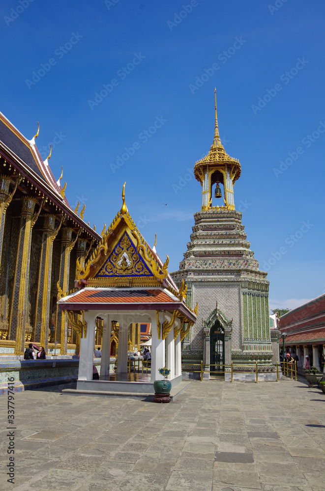 Fototapeta premium A Thai traditional bell tower (belfry) with detailed, mosaic artwork and gold colored design at Wat Phra Kaew (Temple of the Emerald Buddha) within the precincts of the Grand Palace of Bangkok