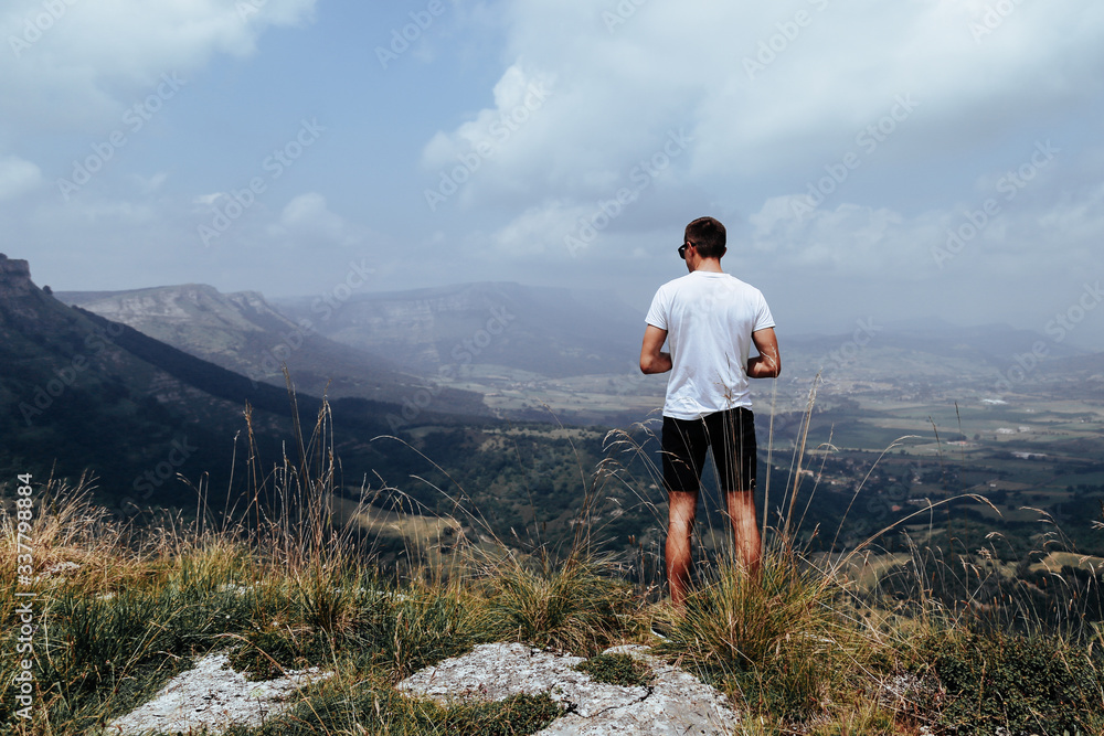 Male on top of a large mountain having a panoramic view towards a canyon Salto de Nervion. Burgos. Spain Male on top of a large mountain having a panoramic view towards a canyon Salto de Nervion. Burgos. Spain