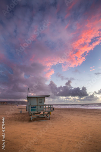 The skies explode in color during sunset over a lifeguard stand in Hermosa Beach, California.