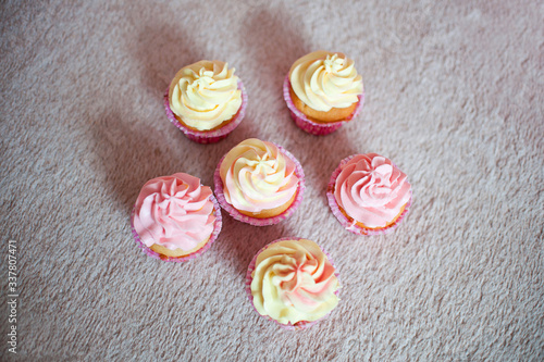 cupcakes with cream pink and yellow on a cream background