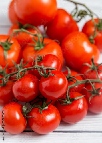 Close up tomatoes on white wooden background © Тоня Коренева