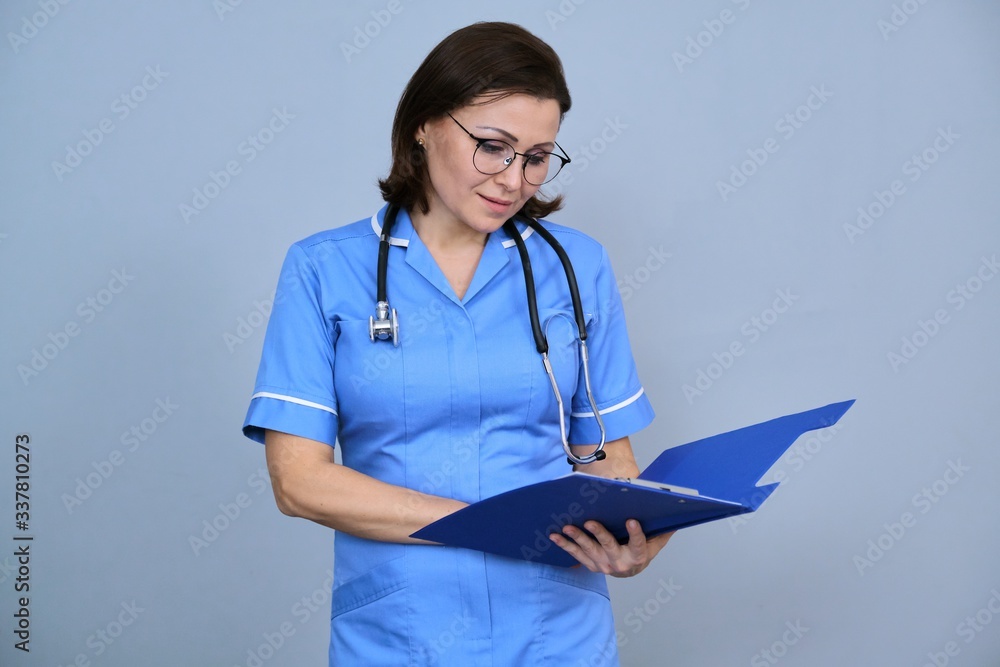 Portrait of mature nurse woman holding clipboard Portrait of mature nurse woman holding clipboard