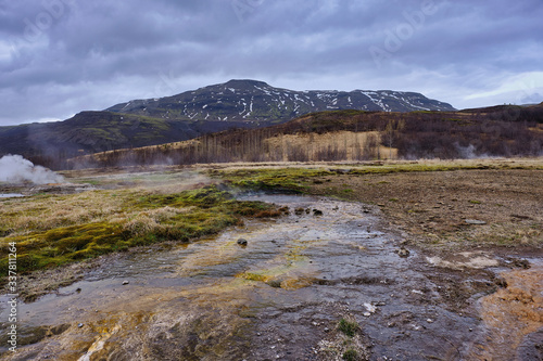 Hot water runoff from the Stokkur Geyser in Iceland and the surrounding landscape