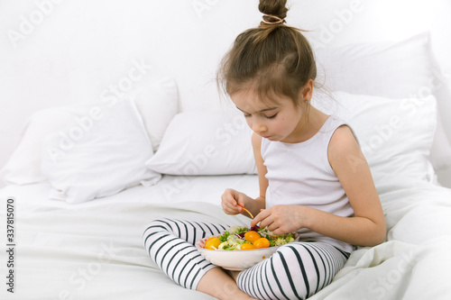 Cute little girl with fruits and vegetables.