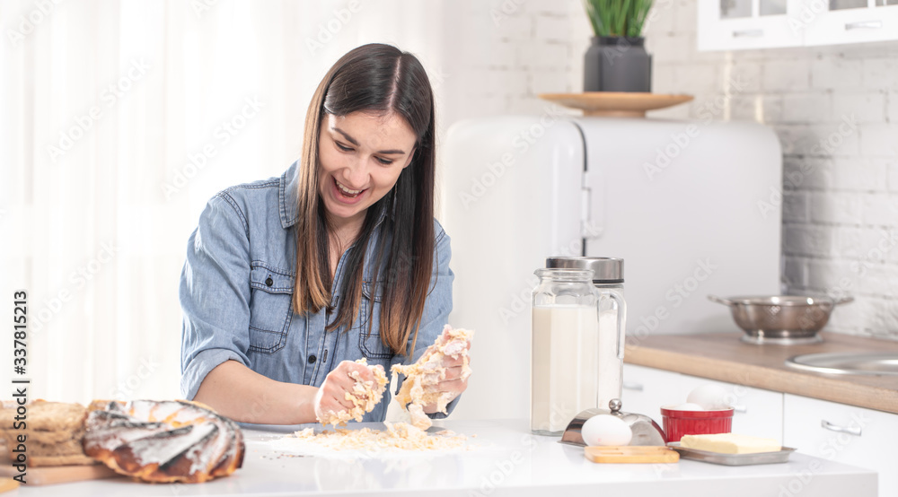 A young beautiful woman prepares homemade cakes in the kitchen.