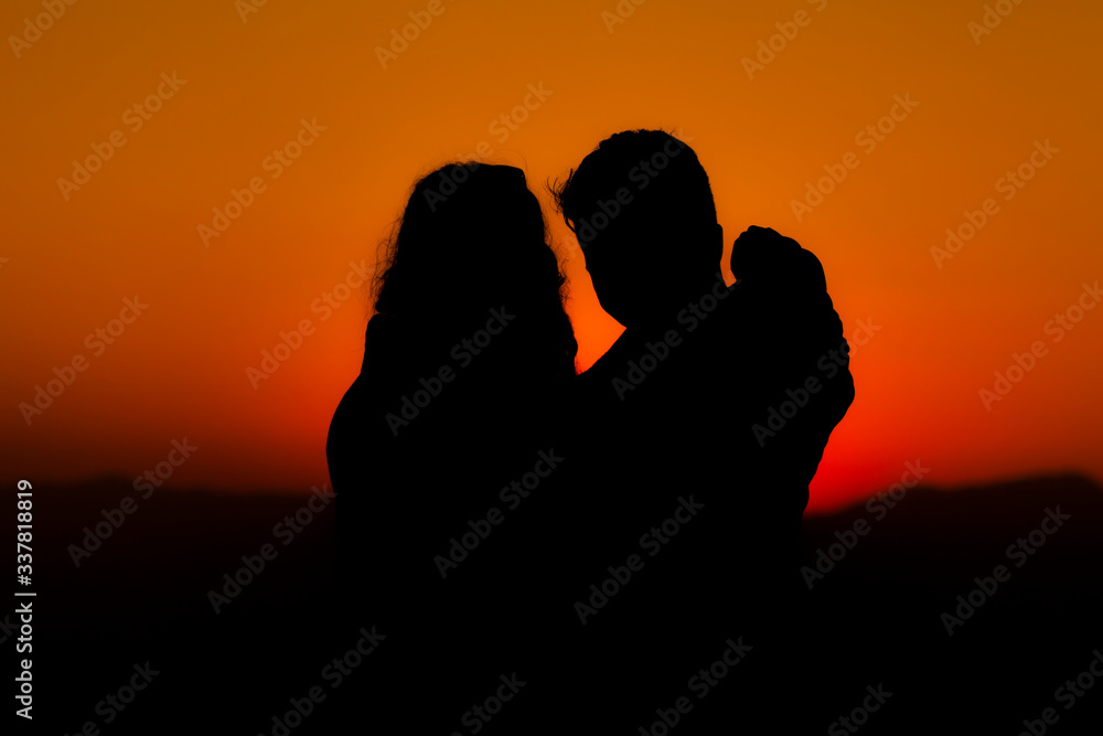 Silhouette of a womanwith a backpack in thesunset.
