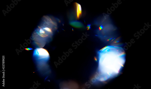 Lens Flare, Abstract Bokeh Lights. Leaking Reflection of a Glass, Diamond,  Crystal. Jewelry. Defocused Shining Colorful rainbow Light Leaks, Rays on Black Background
