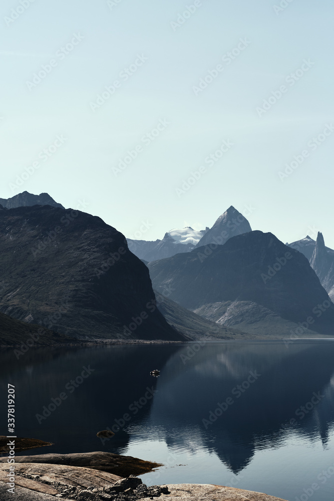 Landscape photo with mountains reflecting in the  fjord