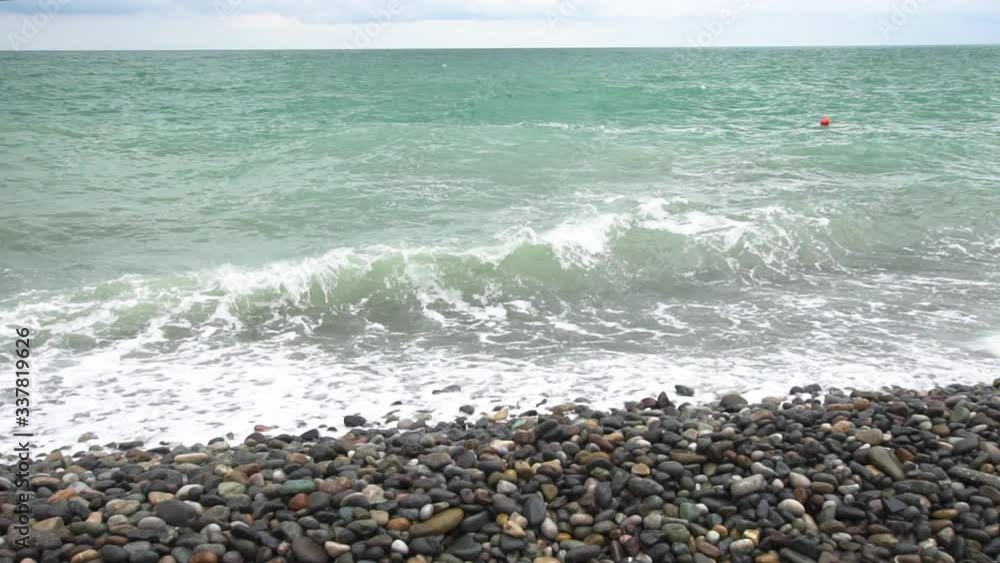 Sea waves roll on pebbles shore during a light storm slow motion slow motion Sea waves roll on pebbles shore during a light storm slow motion slow motion
