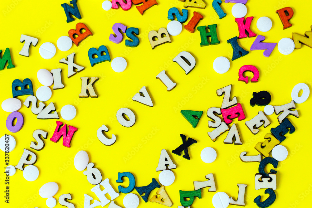 The wooden letters are the word covid. Concept on the theme of flu, virus. The wooden letters are the word covid. Concept on the theme of flu, virus.