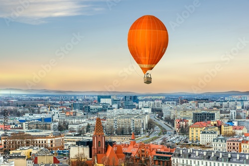 An orange balloon flies over the city