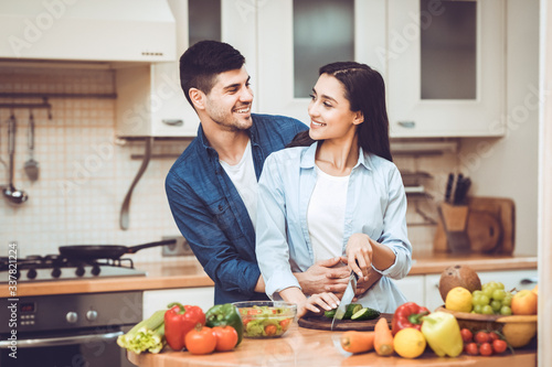 Young couple preparing salad together at home