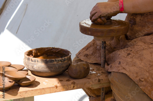 Woman makes pottery on an ancient pottery machine