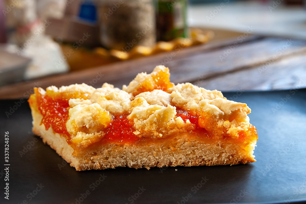 Home-made cake with apricots. Slice of rustic hot sweet pie on a black plate on a wooden background. Natural organic food. Selective soft focus. Home-made cake with apricots. Slice of rustic hot sweet pie on a black plate on a wooden background. Natural organic food. Selective soft focus.