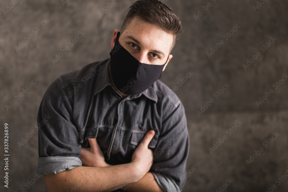 Young man with black mask in dark room pray for world and coronavirus quarantine Young man with black mask in dark room pray for world and coronavirus quarantine