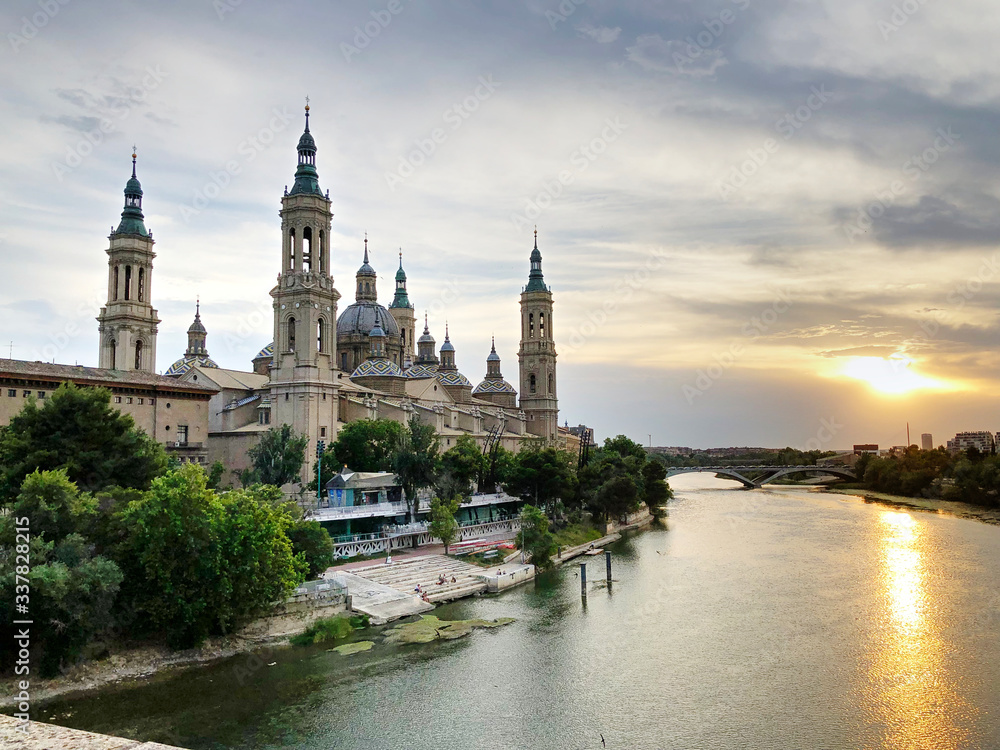 The Cathedral-Basilica of Our Lady of the Pillar, a Roman Catholic church in the city of Zaragoza, in Aragon, Spain, on river Ebro seen by the Old Stone bridge at sunset