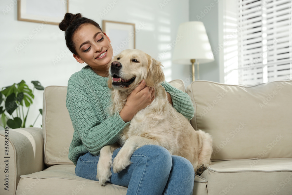 Young woman and her Golden Retriever on sofa at home. Adorable pet Young woman and her Golden Retriever on sofa at home. Adorable pet