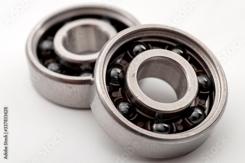 Technical solutions, engine engineering and machinery parts moving concept with metallic alloy deep groove mechanical ball bearing isolated on white background
