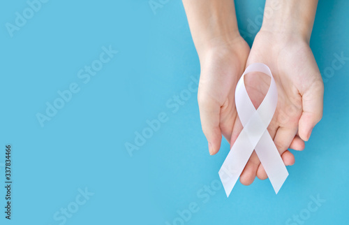 White symbolic ribbon - In defense of a traditional family on a white background. The problem of multiple exostoses. The issue of protecting women from violence on a blue background