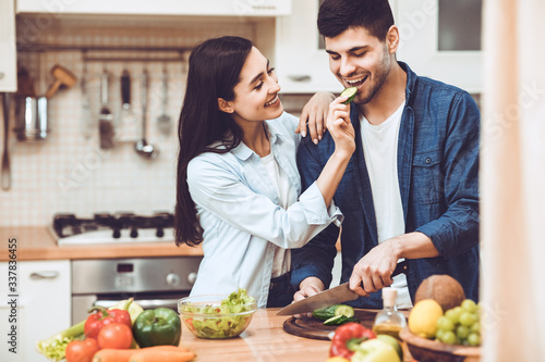 Lovely young couple preparing salad together at home