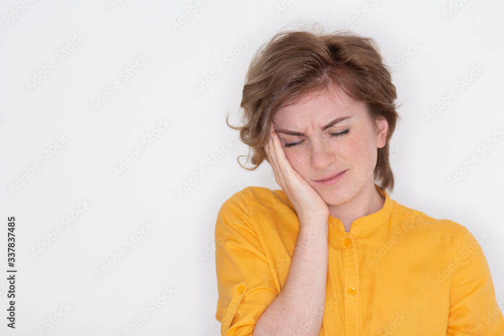 An unhappy, exhausted girl with closed eyes, touches her temples in close-up, a tired woman suffers from a headache or migraine, does not feel well, suffers from insomnia, lack of sleep An unhappy, exhausted girl with closed eyes, touches her temples in close-up, a tired woman suffers from a headache or migraine, does not feel well, suffers from insomnia, lack of sleep