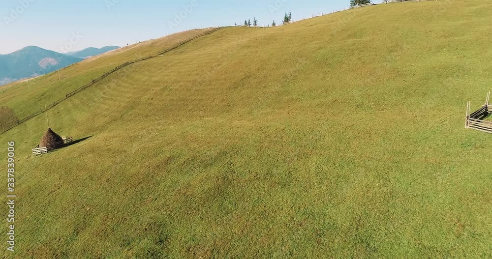 Aerial view of the beautiful mountains and the green meadow on the hill. Drone shot of a Verkhovyna village in the mountains at sunset, Carpathian Mountains, Ukraine. Aerial view of the beautiful mountains and the green meadow on the hill. Drone shot of a Verkhovyna village in the mountains at sunset, Carpathian Mountains, Ukraine.