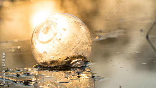 glass ball on the hand  against the backdrop of a beautiful sunset. Sunset water. Reflection in water