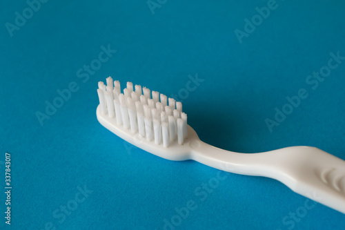 Close up plastic white tooth brush on blue background dental hygiene