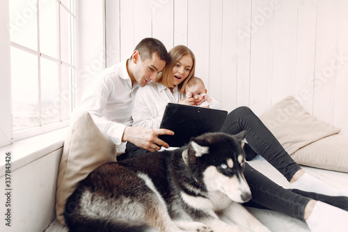 Cute family in a room. Lady in a white shirt. Family sitting with tablet.