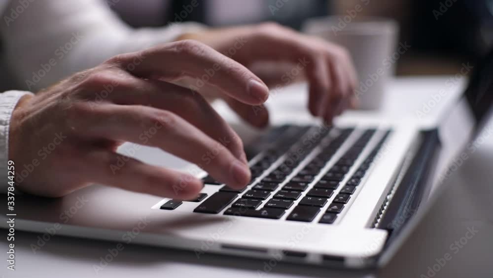 Close-up of man hands typing on laptop keyboard at desk in home. Businessman hands typing on keyboard. Shooting in slow motion. Close-up of man hands typing on laptop keyboard at desk in home. Businessman hands typing on keyboard. Shooting in slow motion.