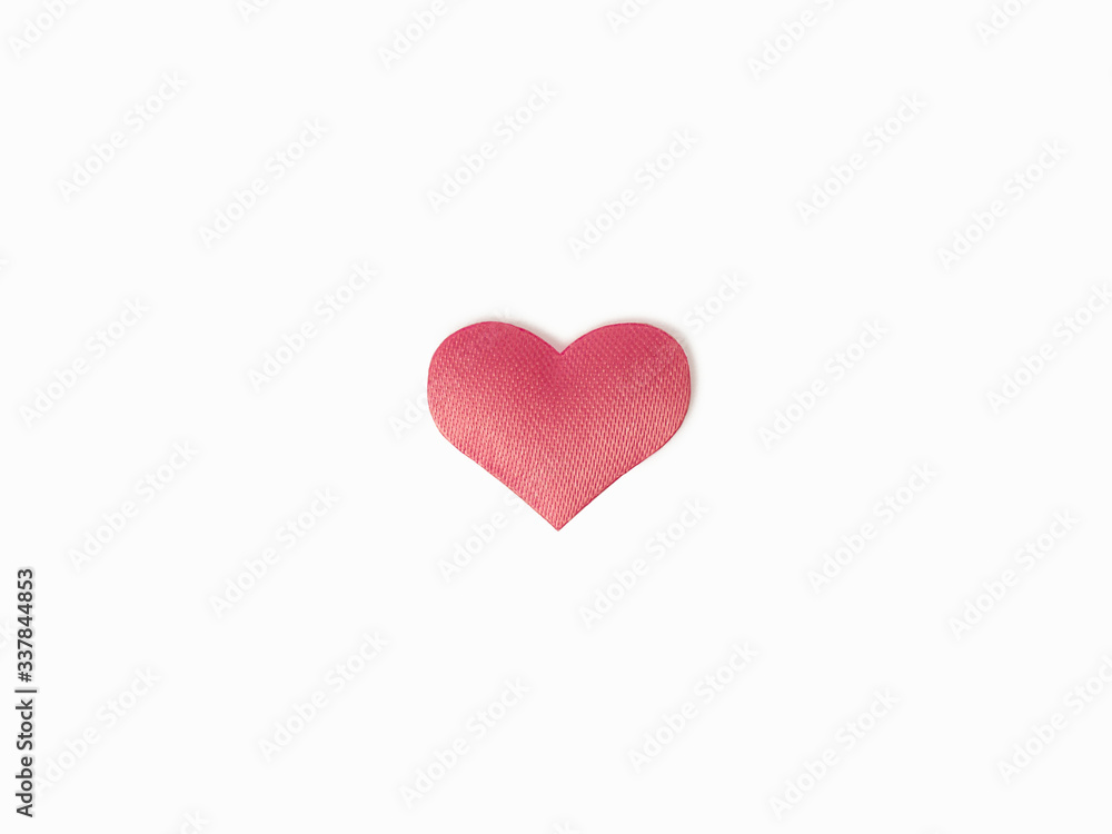 One pink heart made of silk fabric on a white, isolated background