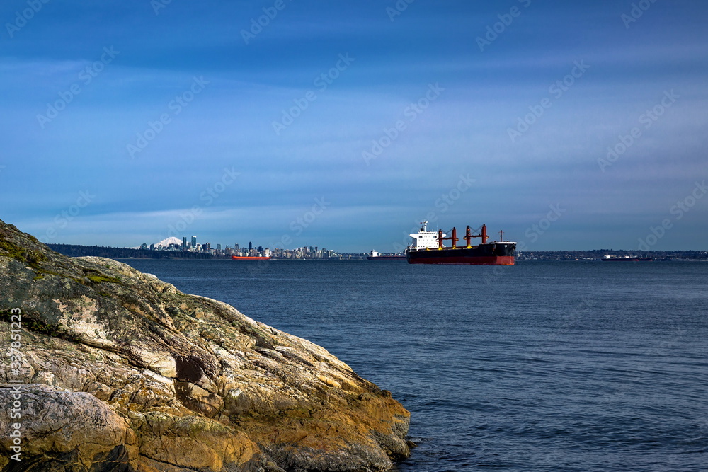 Coastline,  Rocky beach in the  Strait of Georgia, View of Downtown Vancouver,  Ocean tankers are waiting for their turn to load in the sea port in Vancouver harbor