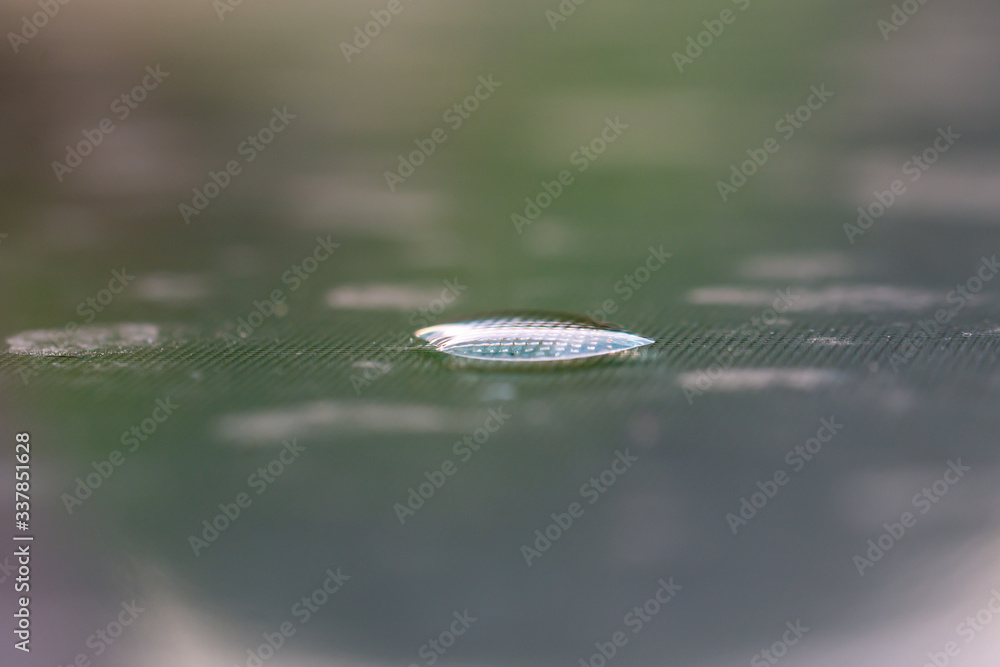 Nice blue effect of light on water drops on a polycarbonate table in
