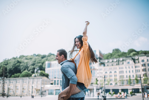 Joyful woman riding piggyback on boyfriend