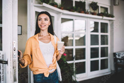 Ethnic woman standing with cup of coffee in city Free Download Ethnic woman standing with cup of coffee in city - GFXLoad