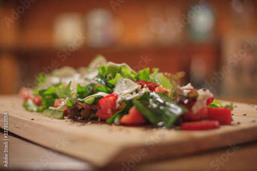 Salad on a wooden long board. Closeup on a wooden table