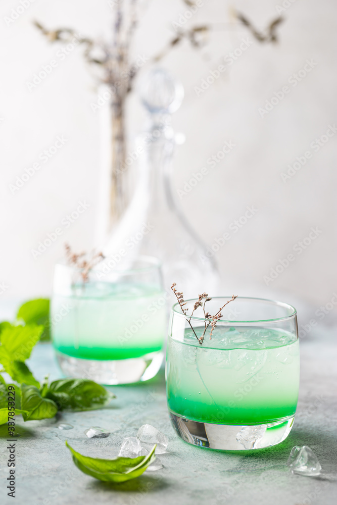 Cold summer drink with basil leaves in glasses. Mojito, iced tea, lemonade with basil. Cold summer drink with basil leaves in glasses. Mojito, iced tea, lemonade with basil.
