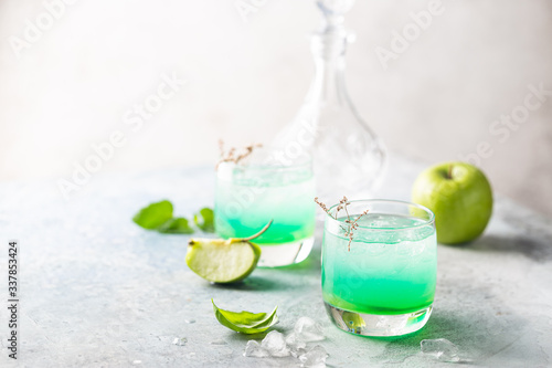 Green cocktail with apples on white background, martini cocktail in glasses