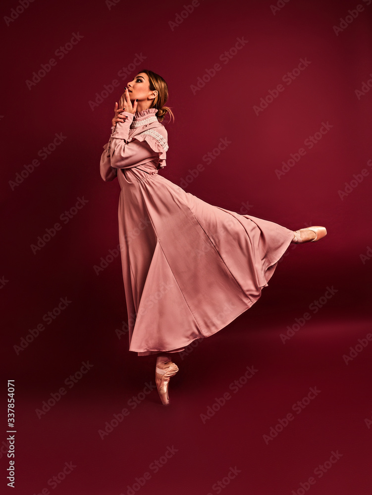 Fototapeta premium Ballet dancer or classic ballerina dancing isolated on red background. The dance, grace, artist, contemporary, movement, action and motion concept