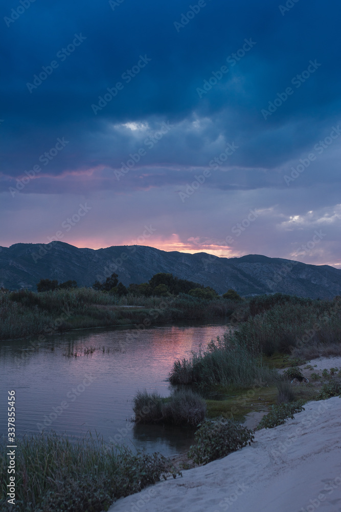 landscape on the background mountain beach along the river at sunset iwith purple sky n xeraco, valencia